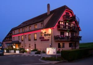 een groot gebouw met een bord ervoor bij Hotel Restaurant Au Riesling in Zellenberg