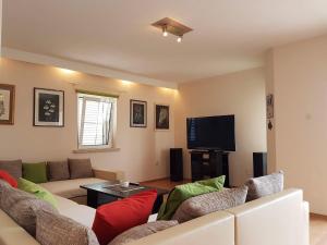 uma sala de estar com um sofá e uma televisão em Apartment Tempera em Povlja