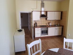 - une cuisine avec des appareils blancs, une table et des chaises dans l'établissement Vilhelm's Apartment, à Klaipėda
