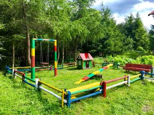 un parque infantil en un campo con un equipo de juegos en Vedmid, en Ludvikuvka