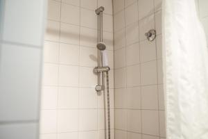 a shower with a shower head in a bathroom at FT Hotel in Freiburg im Breisgau