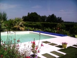 una piscina en medio de un jardín en Maison à la campagne en Lavergne