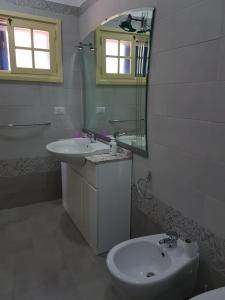a white bathroom with a sink and a mirror at La Capasa B&B in Sannicola