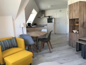 a living room and kitchen with a table and chairs at De Haan in De Haan