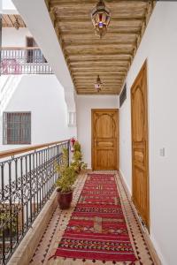 um corredor com uma porta de madeira e um tapete em Hostel Amour d'auberge em Marrakech