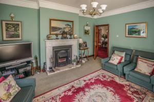 a living room with a fireplace and a tv at Tattykeel House in Omagh