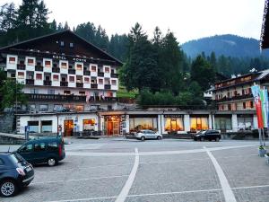a large hotel with cars parked in a parking lot at Albergo Posta in Colle Santa Lucia