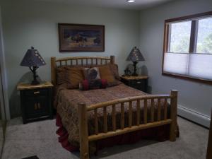 um quarto com uma cama de madeira e 2 mesas de cabeceira em Five Peaks em Buena Vista