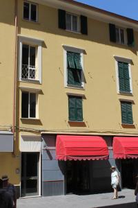 a person standing in front of a building with red awnings at Capitan Nemo-Golfo dei Poeti in La Spezia