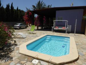 a swimming pool in a yard with a car parked at Cortijillo Violeta in Agua Amarga