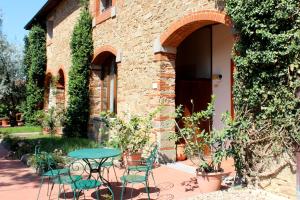 a patio with a table and chairs in front of a building at Agriturismo Antico Borgo Poggitazzi in Loro Ciuffenna