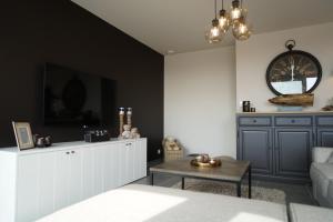 ミッデルケルケにあるMaison Louiseのリビングルーム(ソファ、壁掛け時計付)