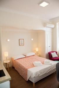 a bedroom with a large bed and a red chair at ALBIAPPART(2) in Albi