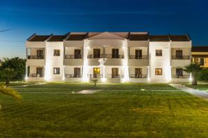 a large white building with a large yard at Stemma Hotel in Sidari