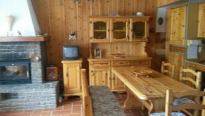 a kitchen with a wooden table and a fireplace at Genevris in Pragelato