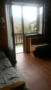 a bedroom with a bed and a view of a balcony at Genevris in Pragelato
