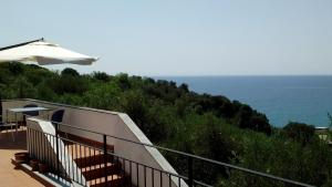 a balcony with an umbrella and the ocean at Il Capriolo in Celle Ligure