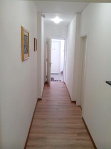 a long hallway with white walls and wood floors at Maja rooms in Split