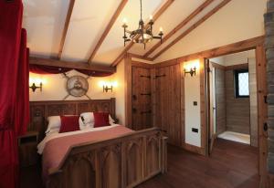 a bedroom with a bed and a dresser at Warwick Castle Knight's Village in Warwick