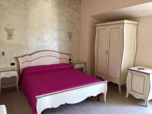 1 dormitorio con 1 cama blanca y armario en Eleven Bed & Breakfast en Reggio Calabria
