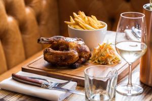 a cutting board with a chicken and french fries on a table at The Porterhouse grill & rooms in Oxford