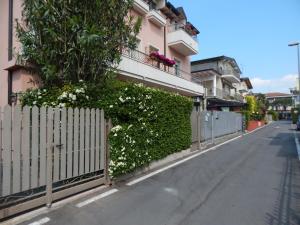 a fence with white flowers on the side of a building at Appartamenti Jamaica in Sirmione