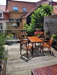 einen Holztisch und Stühle auf einer Holzterrasse in der Unterkunft Hostel Lybeer Bruges in Brügge