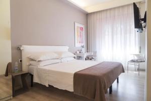 ein Schlafzimmer mit einem großen weißen Bett und einem Fenster in der Unterkunft Residenza Talenti Superior Rooms in Rom