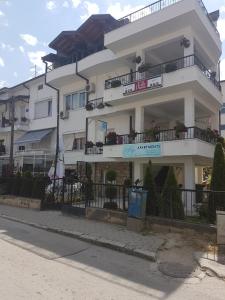 a large white building with balconies on a street at Maja Apartments in Ohrid