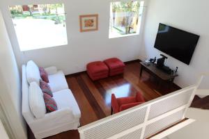 a living room with white furniture and a flat screen tv at Casa 31 Paraty in Paraty