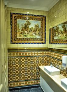 een badkamer met een wastafel en een schilderij aan de muur bij Hostel Lybeer Private Rooms just for two! in Brugge