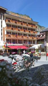 a large building with people on bikes in front of it at Hôtel du Centre in Valloire