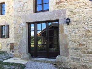 a black door on the side of a stone building at Domaine du Colombier, Chambres d'Hotes in Larroque