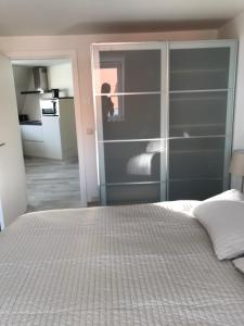 a bedroom with a bed and a person in a kitchen at De Haan in De Haan