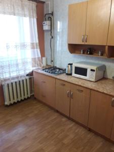 a kitchen with a stove and a microwave on a counter at Апартаменты в центре in Cherkasy