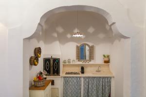 - une cuisine avec un évier et un miroir dans l'établissement Dimore del Faso, à Fasano