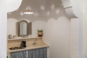 La salle de bains est pourvue d'un lavabo et d'un miroir. dans l'établissement Dimore del Faso, à Fasano