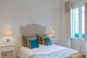 - une chambre avec un lit blanc et des oreillers bleus dans l'établissement Dimore del Faso, à Fasano