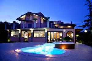 圣焦万尼泰亚蒂诺皇后酒店 的一栋前面有游泳池的大房子