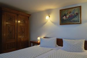フェルテーラーコシュにあるVárfal Vendégházのベッドルーム1室(ベッド2台付)が備わります。壁には絵画が飾られています。