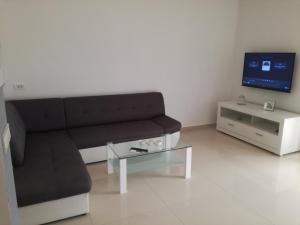 a living room with a black couch and a tv at Ivana Šibenik in Šibenik