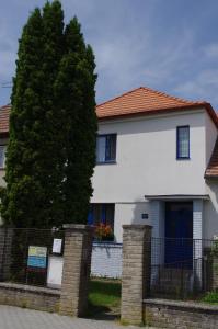 una casa bianca con una recinzione e un albero di Penzion U Thuje a Třeboň