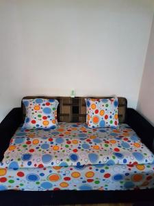 ブラショヴにあるApartamente Marianのベッド1台(カラフルな掛け布団、枕2つ付)
