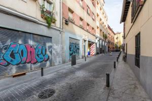 an empty street with graffiti on the side of a building at Plaza Mayor-Rastro WF in Madrid