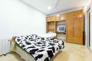 a bedroom with a black and white cow blanket on a bed at Plaza Mayor-Rastro WF in Madrid