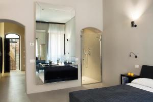 ローマにあるCasa de' Coronari Suitesのベッドルーム1室(洗面台、鏡付きのバスルーム付)