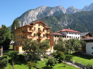 un edificio in un villaggio con montagne sullo sfondo di Paradiso a Vigo di Cadore