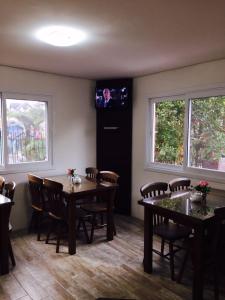 a dining room with tables and chairs and a tv at Pousada Beija Flor Centro in Gramado