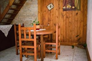 a wooden table and chairs in a room at Arboleda in Jardín América