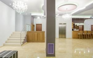 a lobby with a staircase and chandeliers at Hotel Anna in Ioannina